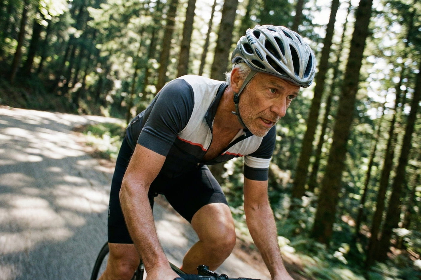Man cycling on a forest path wearing a helmet.