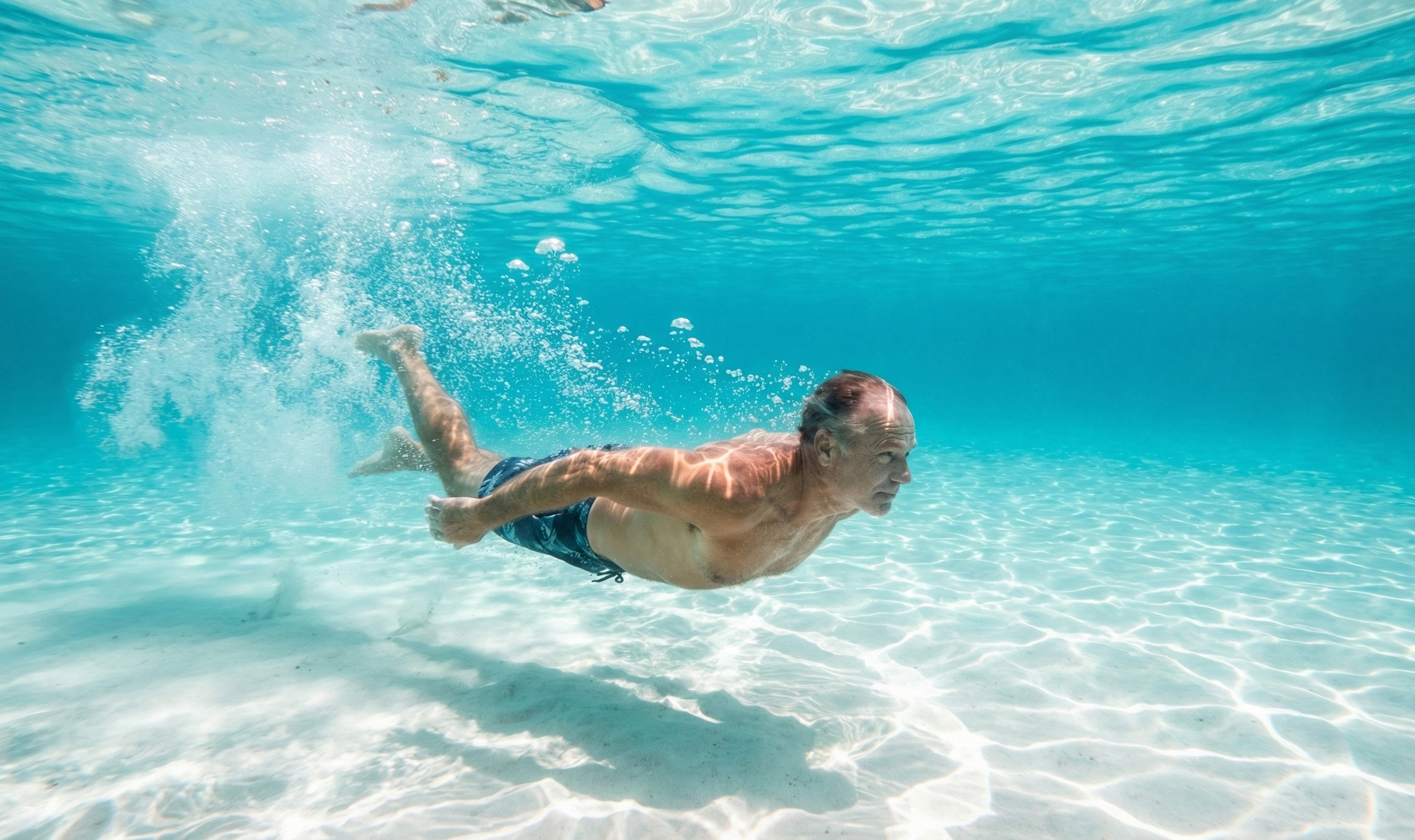 Man swimming underwater in clear blue water